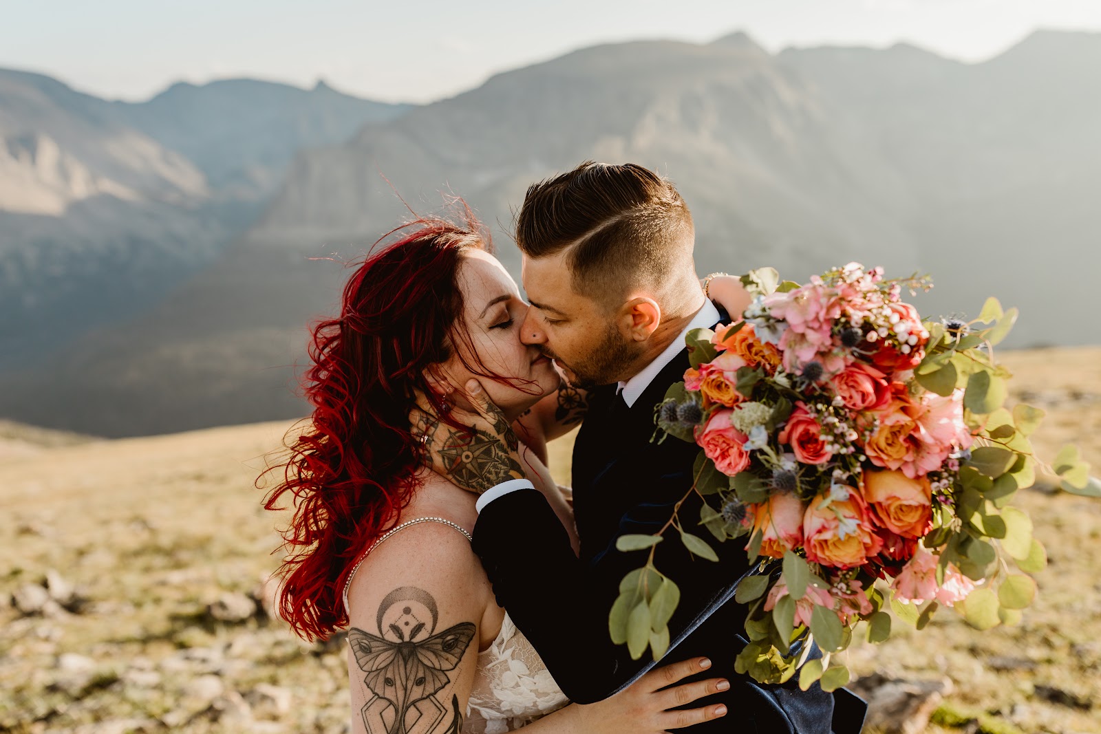 couple kissing in front of a mountain after choosing a wedding photographer