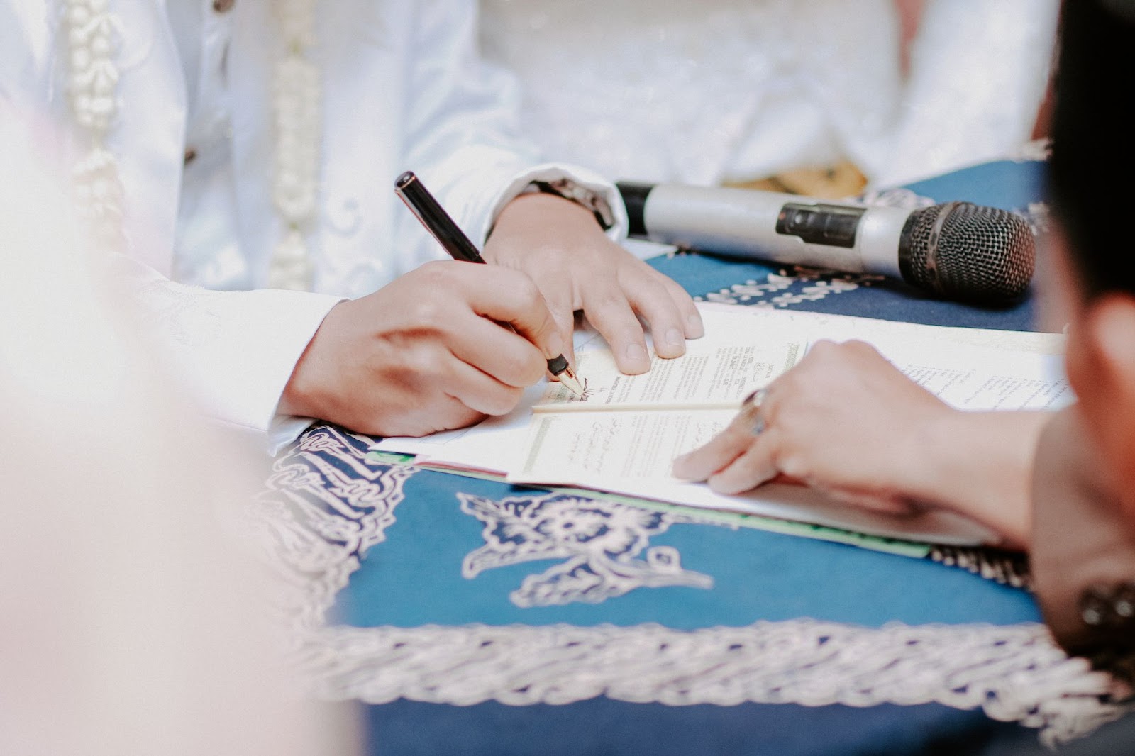 someone signing a marriage license as a way of how to include family members in your wedding ceremony