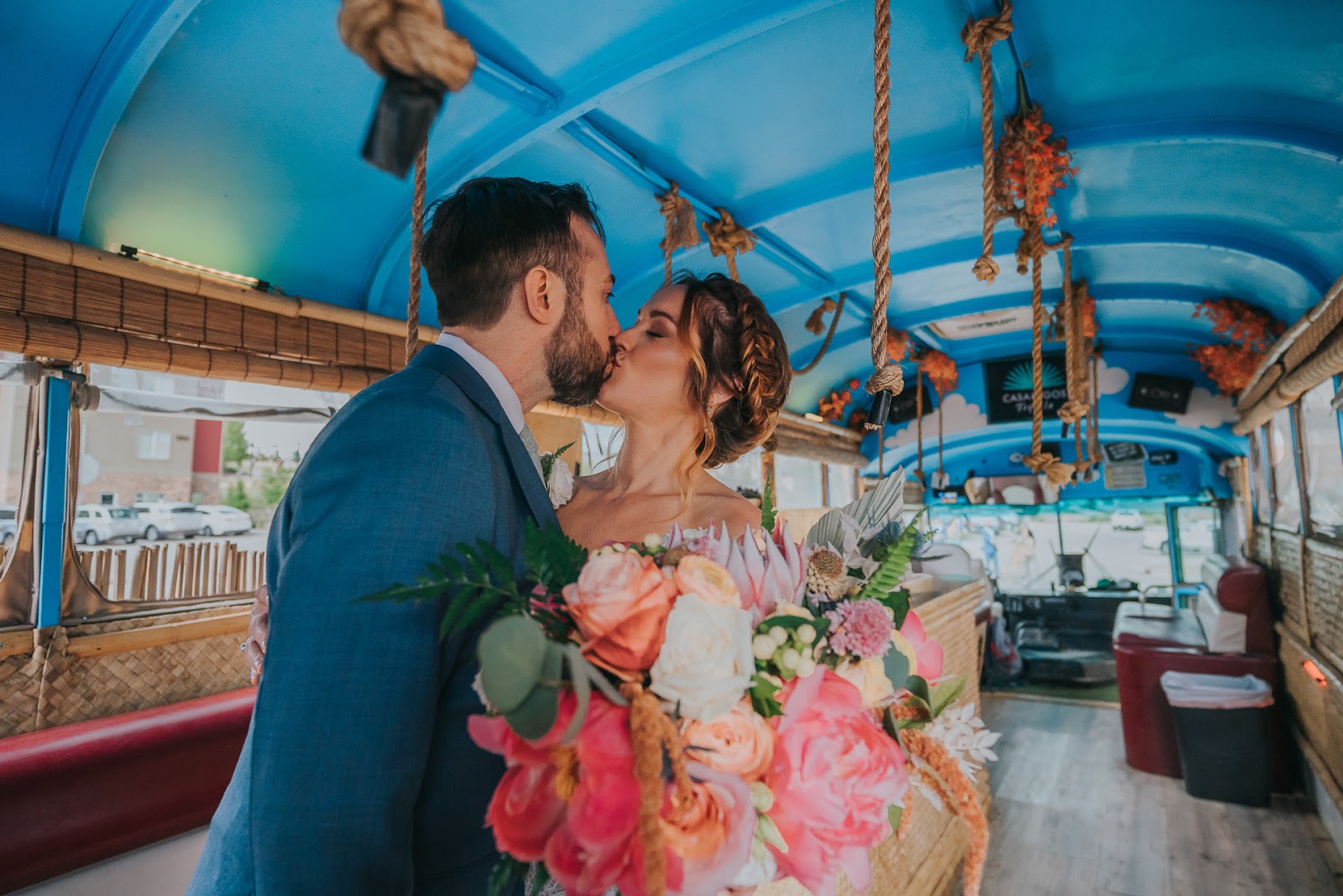 wedding couple kissing in an aesthetic wedding venues of a decorated bus